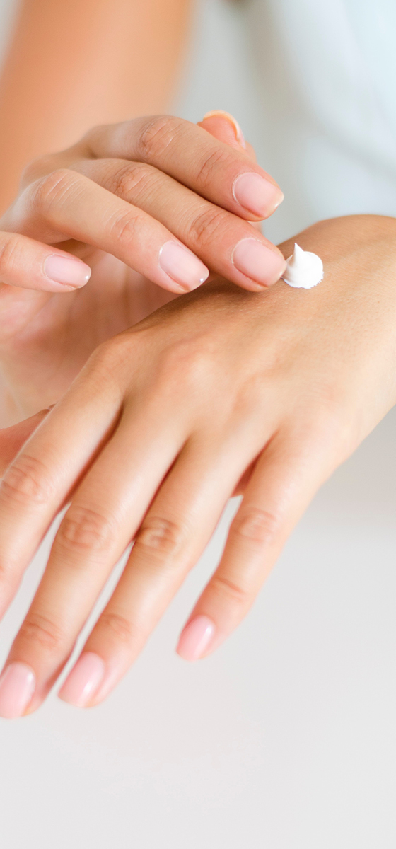 Immagine di mani che si spalmano la crema. 